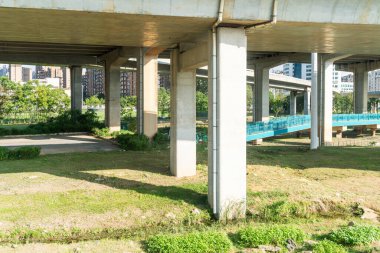 Şehirdeki üst geçidin altında beton yapı ve asfalt yol alanı