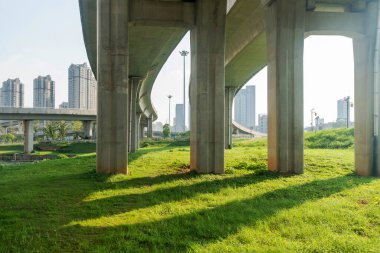 Şehirdeki üst geçidin altında beton yapı ve asfalt yol alanı