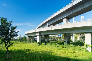 Şehirdeki üst geçidin altında beton yapı ve asfalt yol alanı