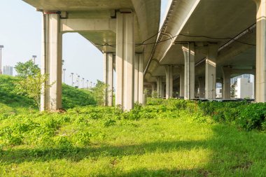 Şehirdeki üst geçidin altında beton yapı ve asfalt yol alanı