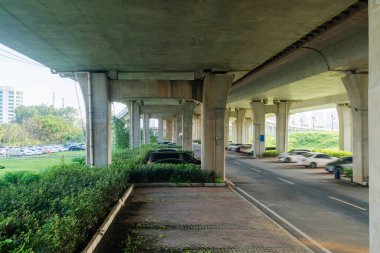Şehirdeki üst geçidin altında beton yapı ve asfalt yol alanı