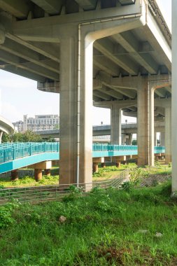 Şehirdeki üst geçidin altında beton yapı ve asfalt yol alanı