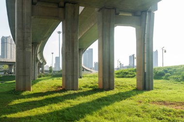 Şehirdeki üst geçidin altında beton yapı ve asfalt yol alanı