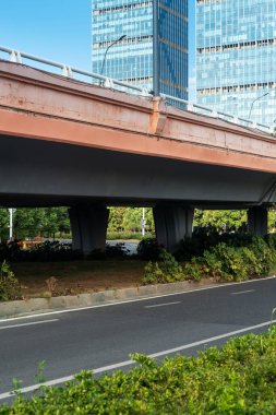 Şehirdeki üst geçidin altında beton yapı ve asfalt yol alanı
