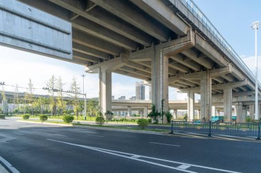Şehirdeki üst geçidin altında beton yapı ve asfalt yol alanı