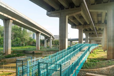 Şehirdeki üst geçidin altında beton yapı ve asfalt yol alanı