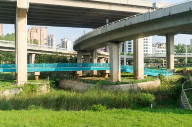 Şehirdeki üst geçidin altında beton yapı ve asfalt yol alanı