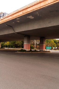 Şehirdeki üst geçidin altında beton yapı ve asfalt yol alanı