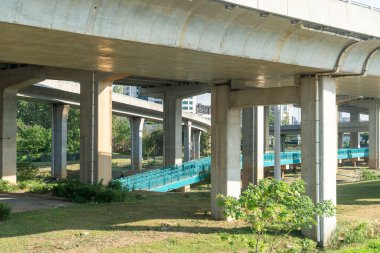 Şehirdeki üst geçidin altında beton yapı ve asfalt yol alanı