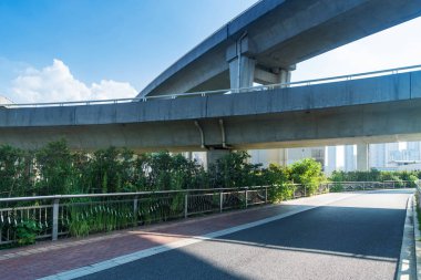 Şehirdeki üst geçidin altında beton yapı ve asfalt yol alanı