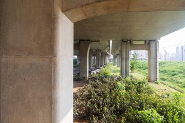 Şehirdeki üst geçidin altında beton yapı ve asfalt yol alanı