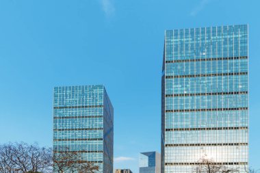 Cam ofis binasının güzel arka planı, açık pencerelerdeki bulutları yansıtıyor.