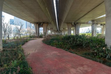 Şehirdeki üst geçidin altında beton yapı ve asfalt yol alanı
