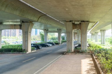 Şehirdeki üst geçidin altında beton yapı ve asfalt yol alanı