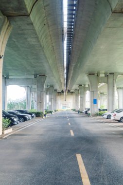 Şehirdeki üst geçidin altında beton yapı ve asfalt yol alanı