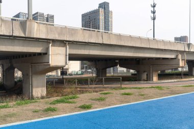 Şehirdeki üst geçidin altında beton yapı ve asfalt yol alanı