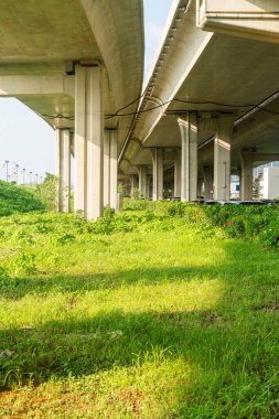 Şehirdeki üst geçidin altında beton yapı ve asfalt yol alanı