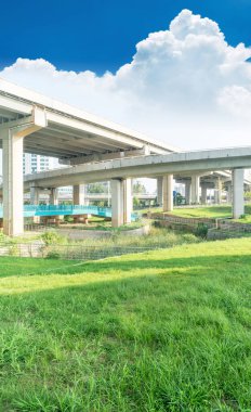 Şehirdeki üst geçidin altında beton yapı ve asfalt yol alanı