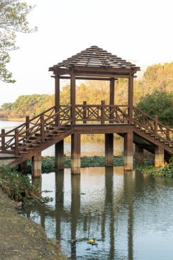 Şehir parkındaki küçük nehrin üzerindeki tahta köprü.