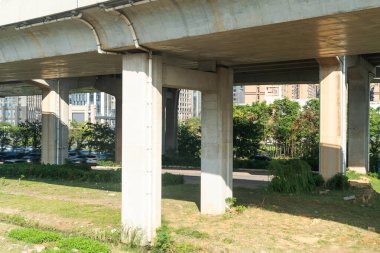 Şehirdeki üst geçidin altında beton yapı ve asfalt yol alanı