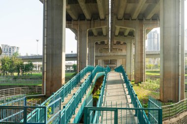 Şehirdeki üst geçidin altında beton yapı ve asfalt yol alanı