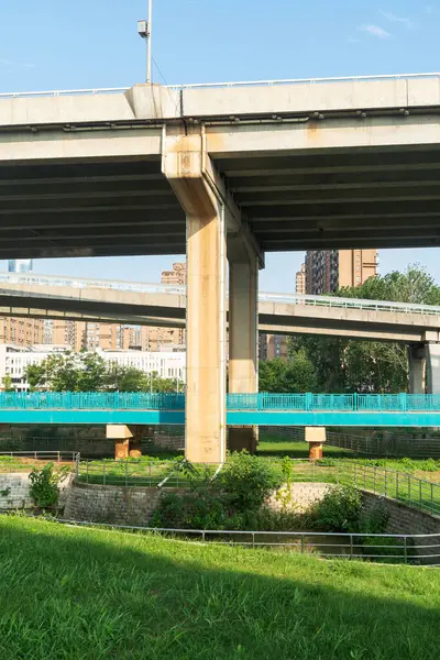 Şehirdeki üst geçidin altında beton yapı ve asfalt yol alanı