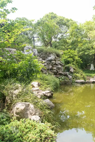 Çin geleneksel taş bahçesi. Yeşil bitkiler ve kayalar