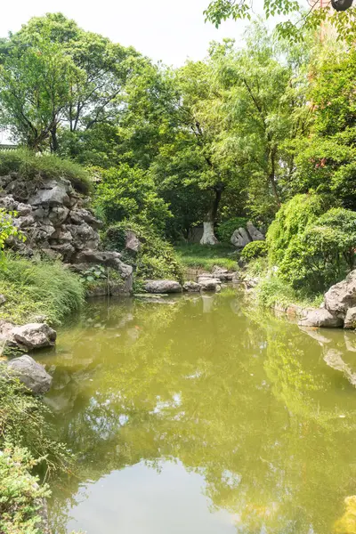 Çin geleneksel taş bahçesi. Yeşil bitkiler ve kayalar