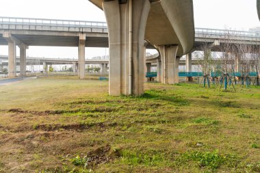 Şehirdeki üst geçidin altında beton yapı ve asfalt yol alanı