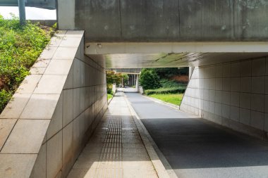 Şehirdeki üst geçidin altında beton yapı ve asfalt yol alanı