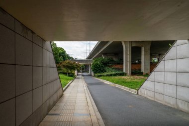 Şehirdeki üst geçidin altında beton yapı ve asfalt yol alanı