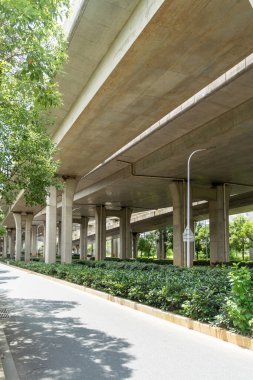 Şehirdeki üst geçidin altında beton yapı ve asfalt yol alanı