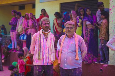 Birçok insan tüm vücudunda boya ile ayakta duruyor ve arkalarında Ujjain, Madhya Pradesh, Hindistan- 18 Mart 2022