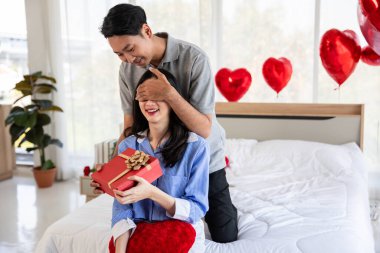 Beautiful young couple surprise with rose and gift in bedroom,Valentine's Day  concept.