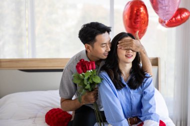Beautiful young couple surprise with rose and gift in bedroom,Valentine's Day  concept.