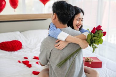 Couple in love hugging in the bedroom with rose and gift Valentine's Day  concept.