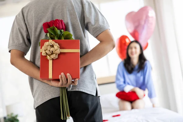loving couple  Man with rose and gift on back in bedroom valentines day concept.