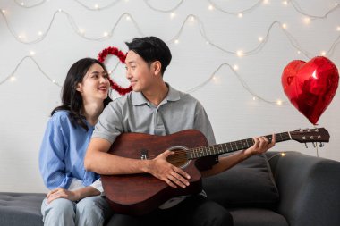 Couple of love playing on guitar for his cute lovely woman,Valentine's Day  concept.