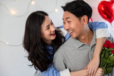 Couple in love hugging in the bedroom with rose and gift Valentine's Day  concept.
