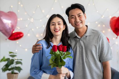 Couple in love hugging in the bedroom with rose and gift Valentine's Day  concept.