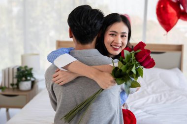 Couple in love hugging in the bedroom with rose and gift Valentine's Day  concept.