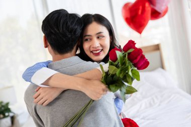 Couple in love hugging in the bedroom with rose and gift Valentine's Day  concept.