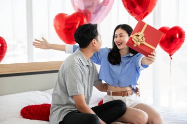 Beautiful young couple surprise with rose and gift in bedroom,Valentine's Day  concept.