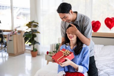 Beautiful young couple surprise with rose and gift in bedroom,Valentine's Day  concept.