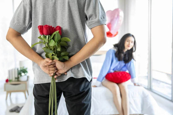 loving couple  Man with rose and gift on back in bedroom valentines day concept.
