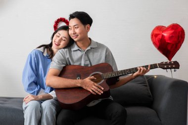 Couple of love playing on guitar for his cute lovely woman,Valentine's Day  concept.