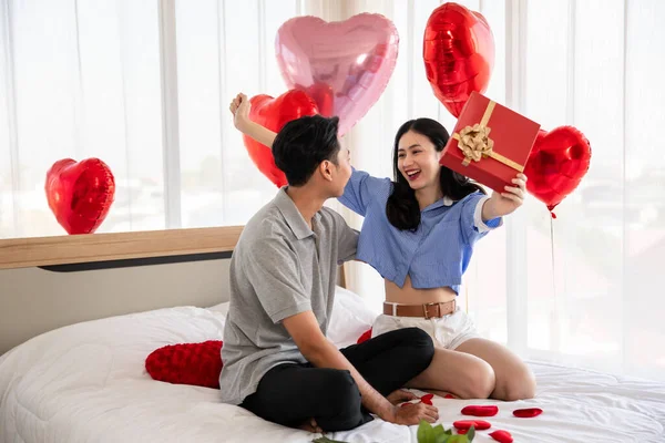 Beautiful young couple surprise with rose and gift in bedroom,Valentine's Day  concept.