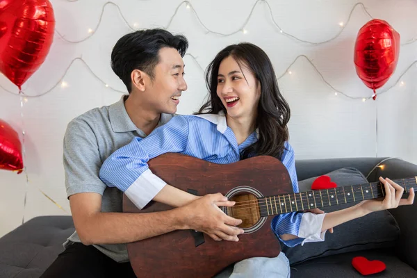 Couple of love playing on guitar for his cute lovely woman,Valentine's Day  concept.