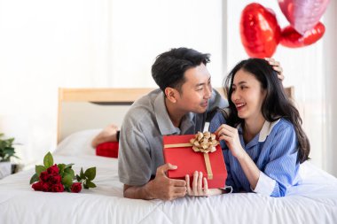 Beautiful young couple surprise with rose and gift in bedroom,Valentine's Day  concept.
