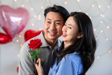 Couple in love hugging in the bedroom with rose and gift Valentine's Day  concept.